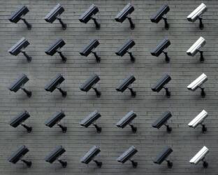 Lots of CCTV cameras mounted on a brick wall