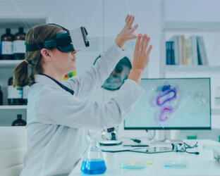 Scientist sitting at desk using VR headset