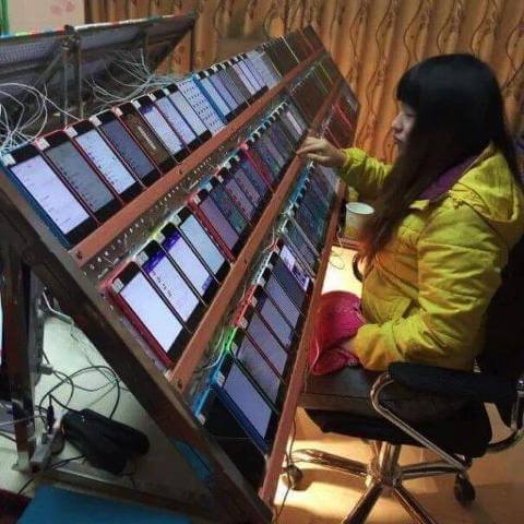 Girl, sitting and looking at a huge array of smartphones