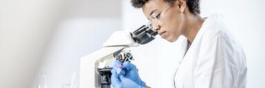 Scientist standing next to microscope