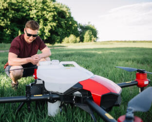 Smart Agriculture Industry Concept Drone Man standing in field looking at drone