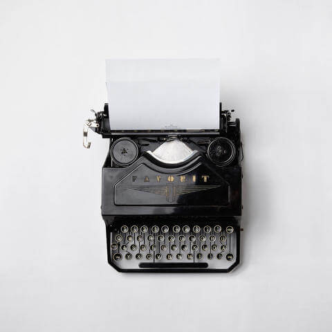 Old, black typewriter on a white background